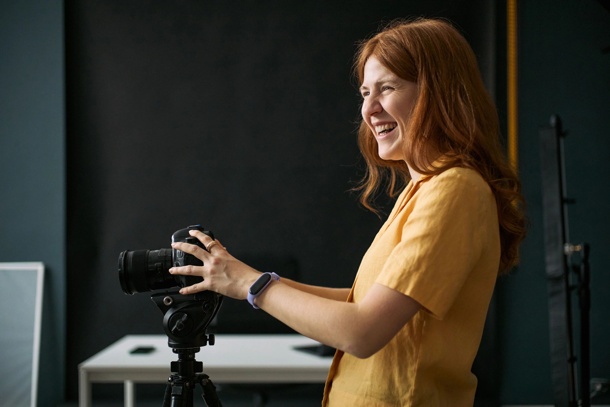 Female photographer preparing camera in studio